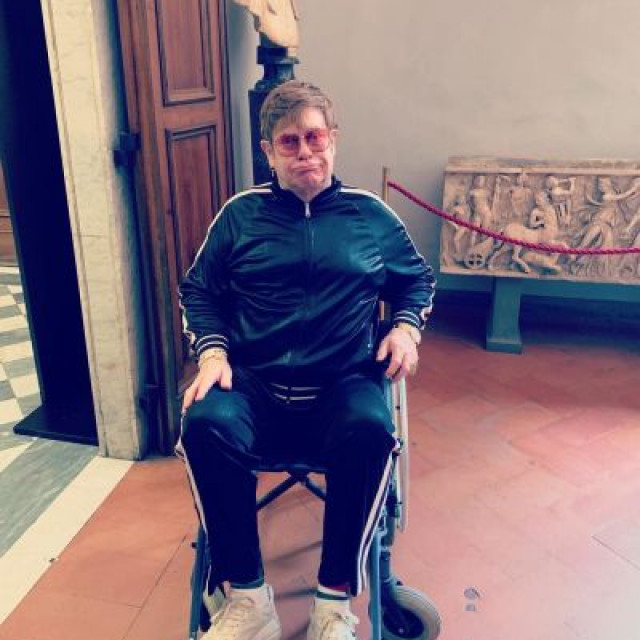 Elton John appears in a wheelchair